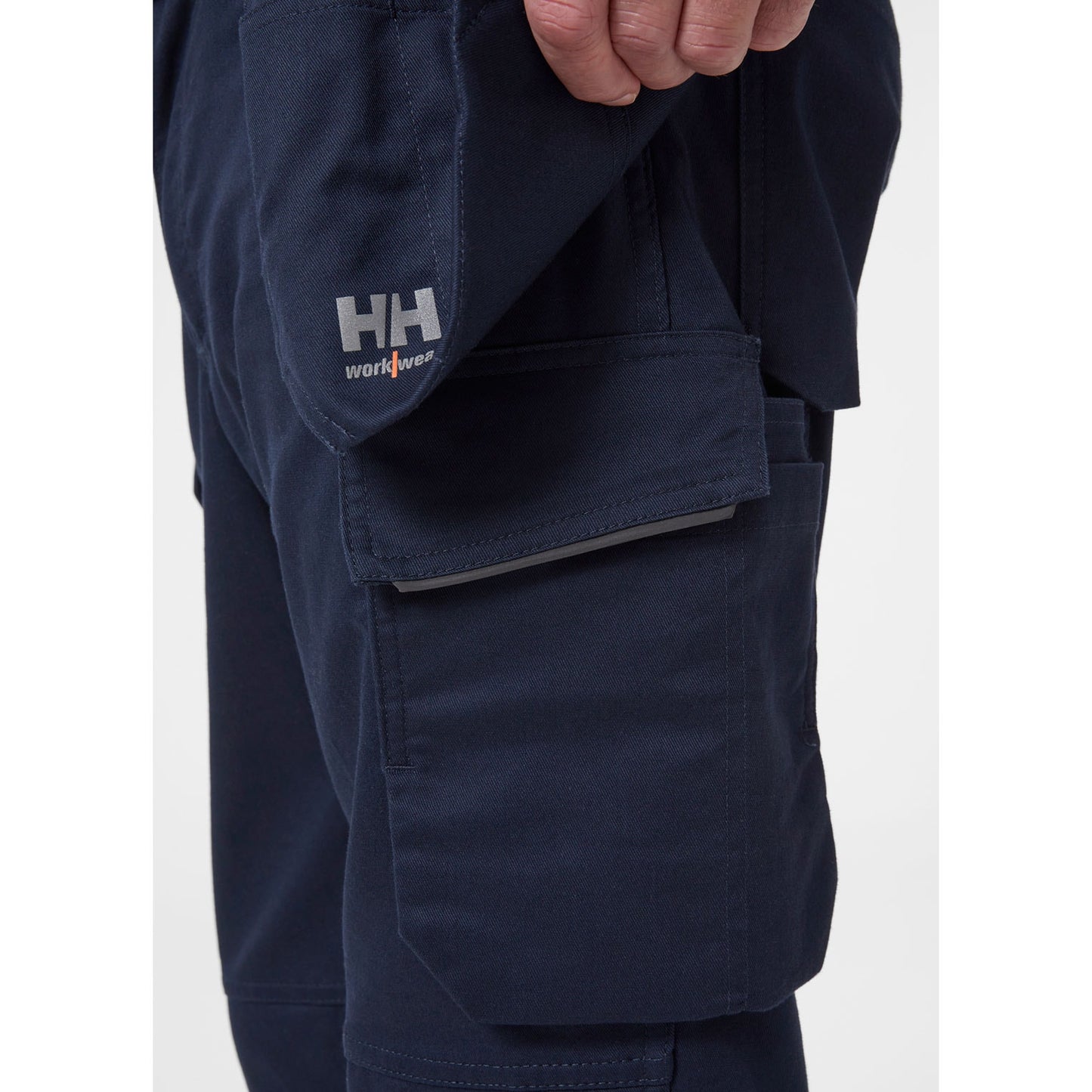 Bližnji posnetek funkcionalnih visečih žepov z dvojnim dnom za vijake in orodje na modrih hlačah Helly Hansen